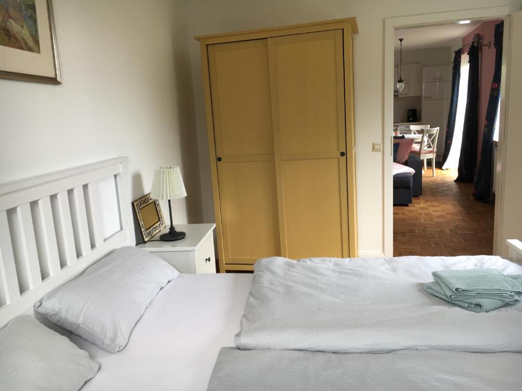 - une chambre avec un lit blanc et un placard dans l'établissement Pension Malwine, à Karlsruhe