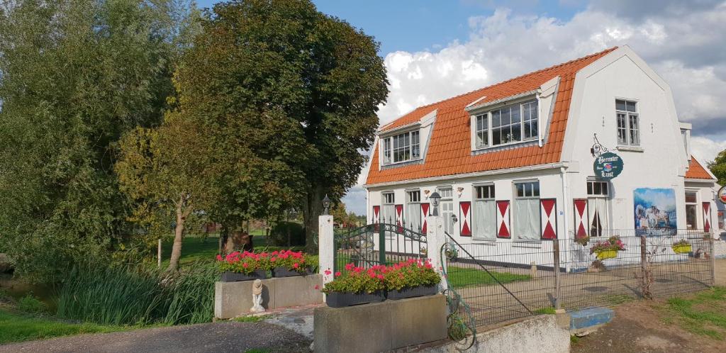 een wit gebouw met bloemen ervoor bij B&B Beemsterlust in Westbeemster