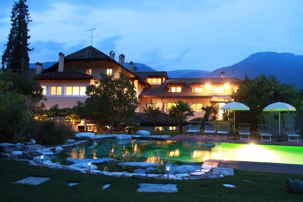 ナッレスにあるKreuzwegerhof Nals Historischer Gutshof, Apartments zw Meran und Bozen Südtirol, Naturpool, zentrale Lageの夜のプールのある家