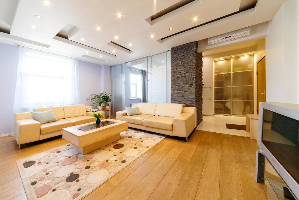 a living room with two couches and a tv at Brivibas LUX in Riga