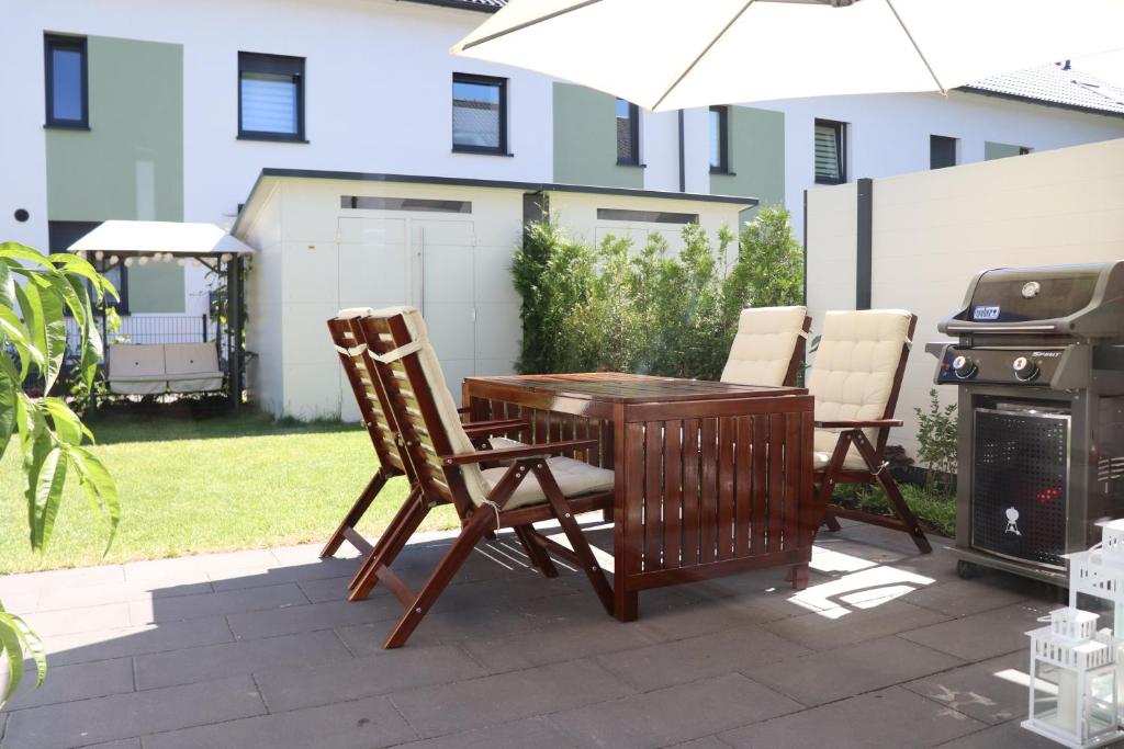 a patio with a table and chairs and a grill at Privatzimmer an der Messe in Hannover