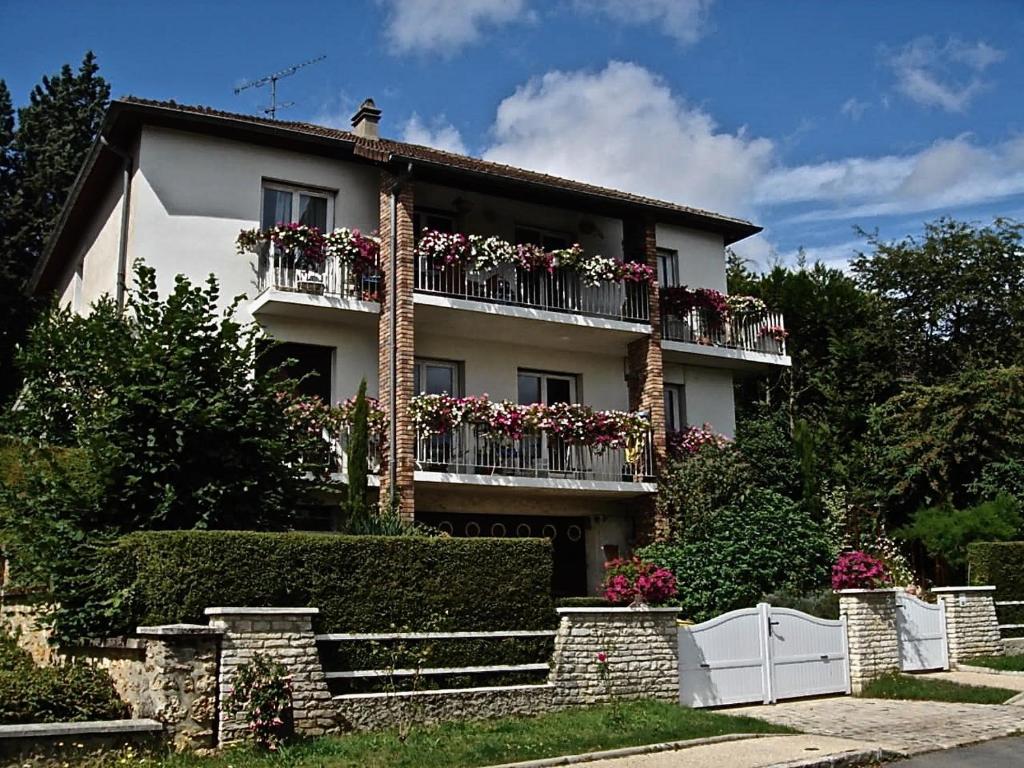 une maison avec des boîtes de fleurs sur les balcons dans l'établissement Appartement 2 pièces neuf et indépendant, à Jouy-en-Josas