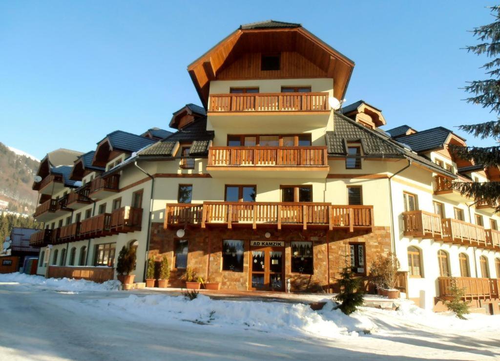 ein großes Gebäude im Schnee davor in der Unterkunft Apartment 20 Kamzík Donovaly in Donovaly