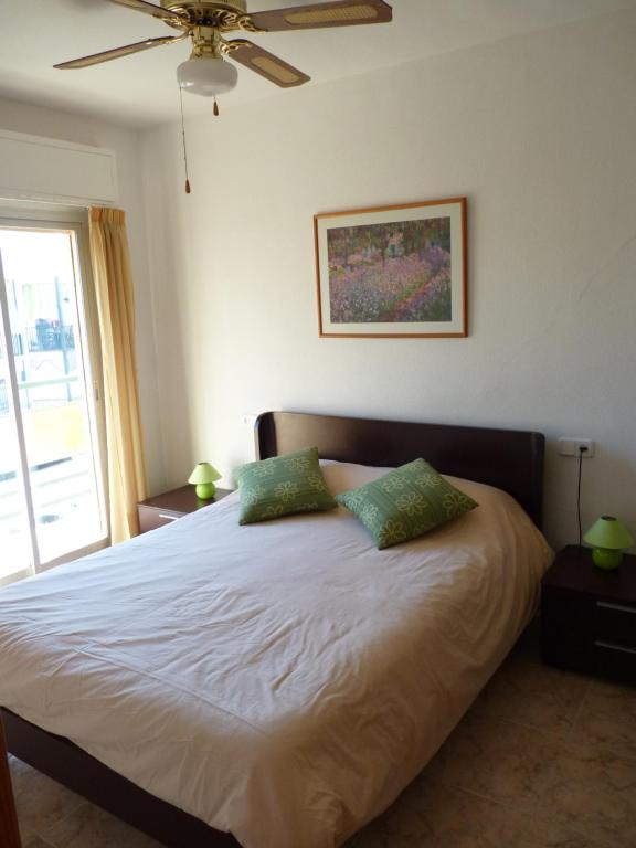 sypialnia z łóżkiem z 2 zielonymi poduszkami w obiekcie NEW centro Torremolinos w mieście Torremolinos
