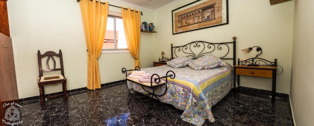 sypialnia z łóżkiem, krzesłem i oknem w obiekcie Comfortable flat in El Fraile w mieście Las Galletas
