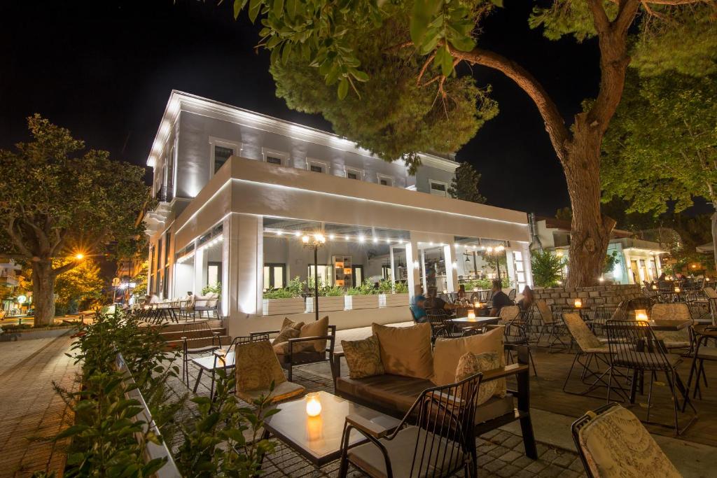 a building with tables and chairs at night at Panellinion Luxury Rooms in Kalamata