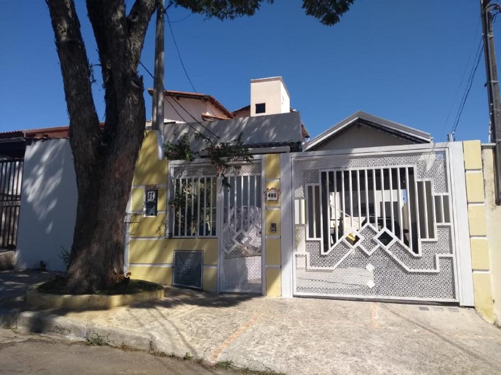 a building with a gate with a tree in front of it at Casa do Henrique 3 in Sorocaba