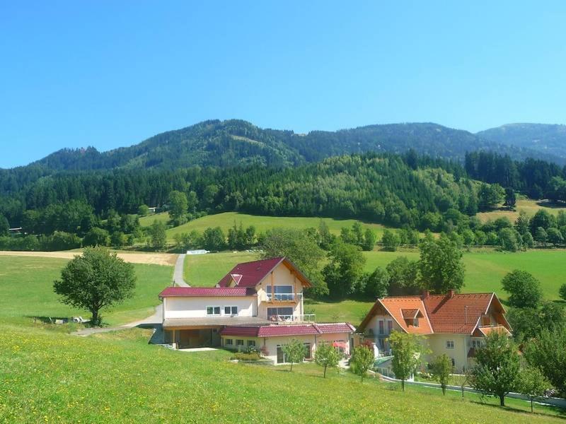 a house in the middle of a green field at Landhaus Griesser in Seeboden