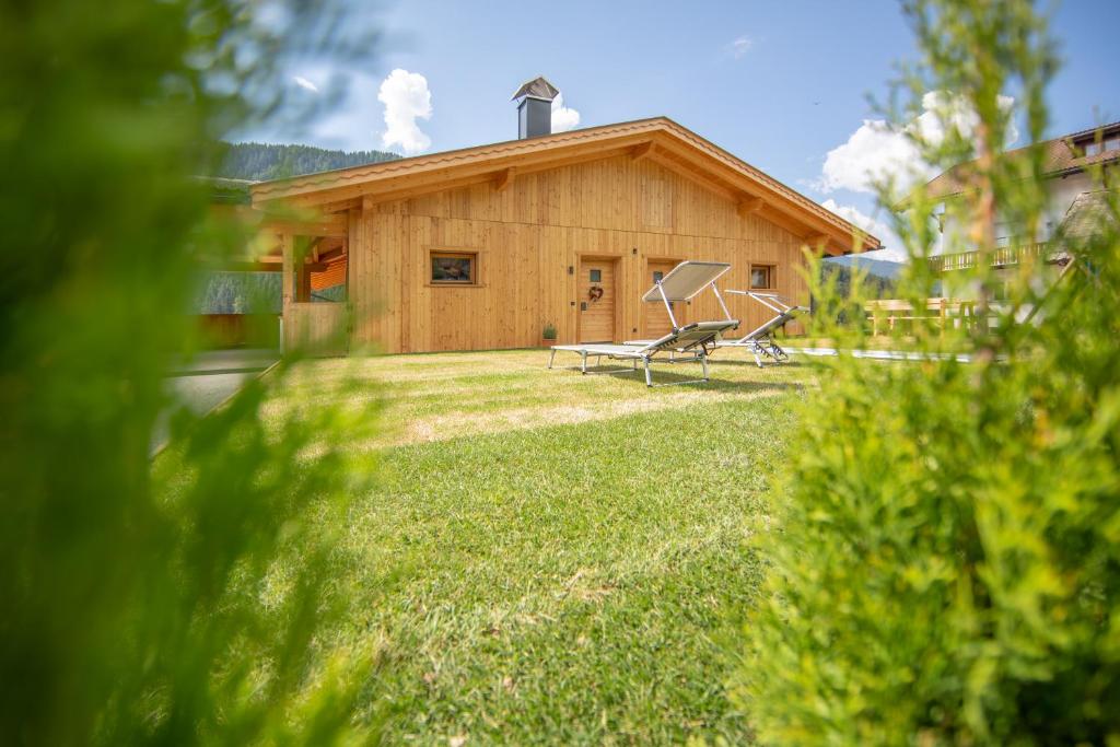 a wooden house with a bench in the yard at Ditterhof in Tesido