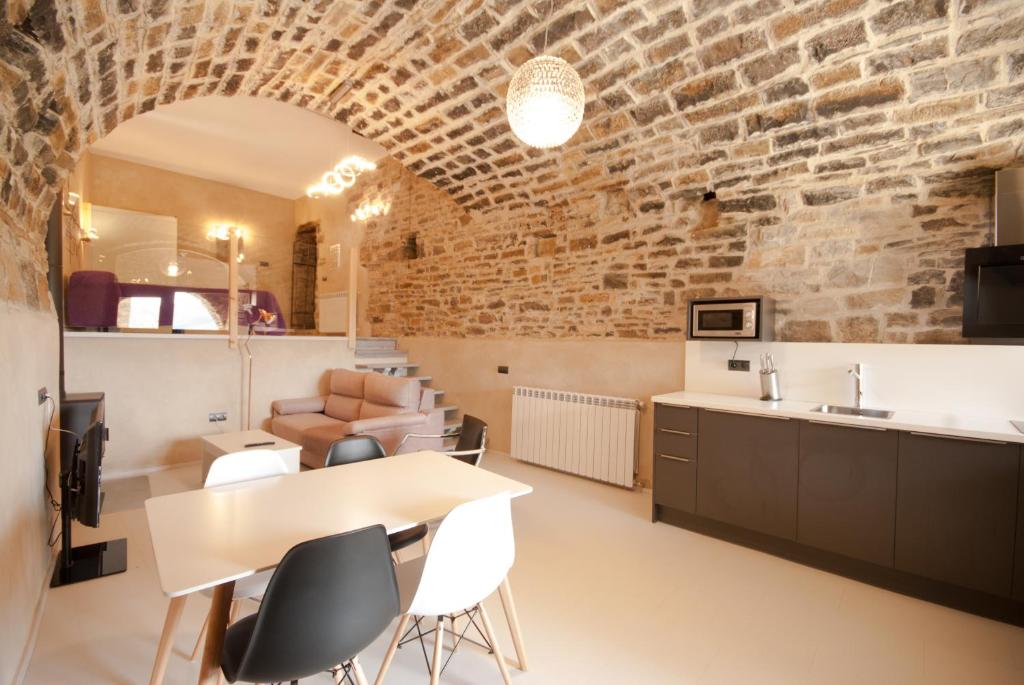 a kitchen and dining room with a brick wall at Casa Mur de Alujan in Tierrantona