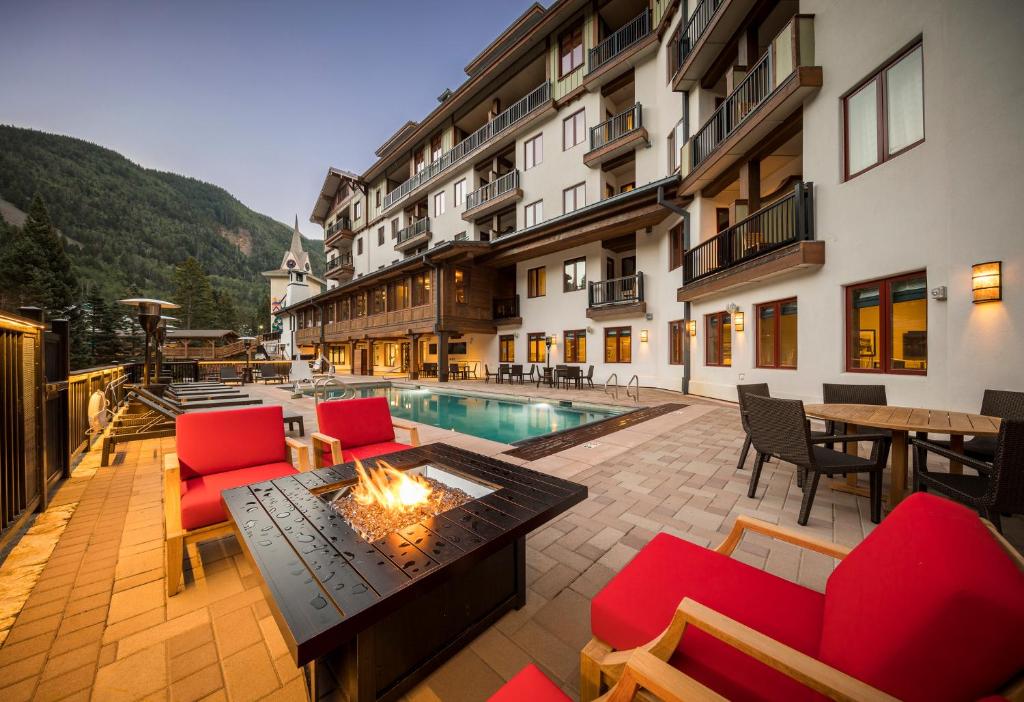 a hotel patio with a fire pit and a pool at The Blake at Taos Ski Valley in Taos Ski Valley