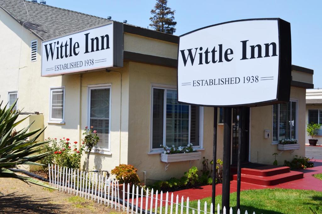 una señal de posada blanca delante de una casa en Wittle Motel en Sunnyvale