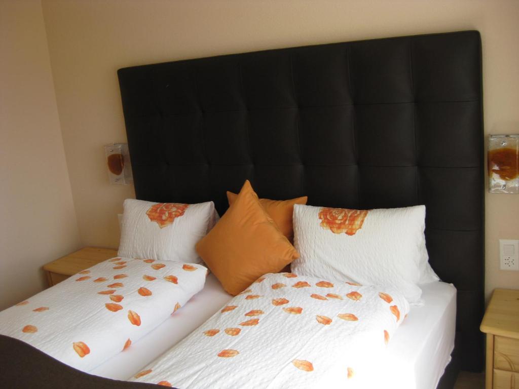 a bedroom with two beds with pillows on them at Hotel Pizzeria Selva in Zernez