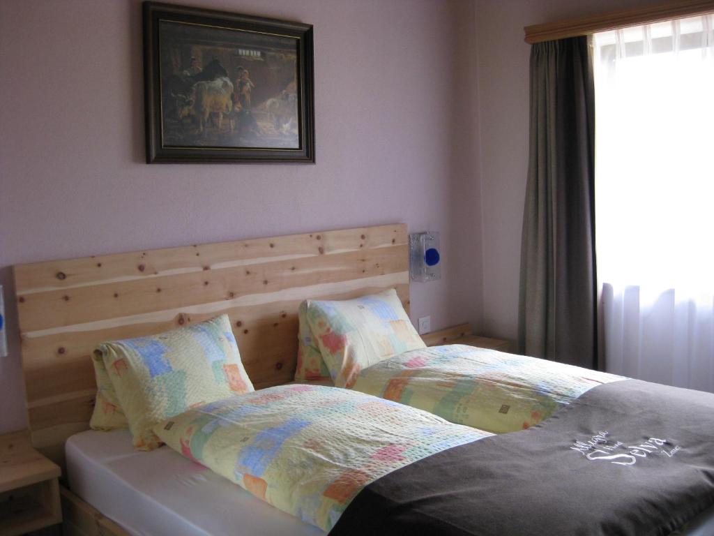 a bedroom with two beds next to a window at Hotel Pizzeria Selva in Zernez