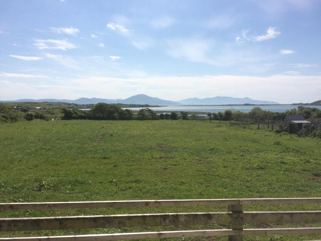 a field with a fence and a view of the water at Barrow Harbour studio apartment in Tralee