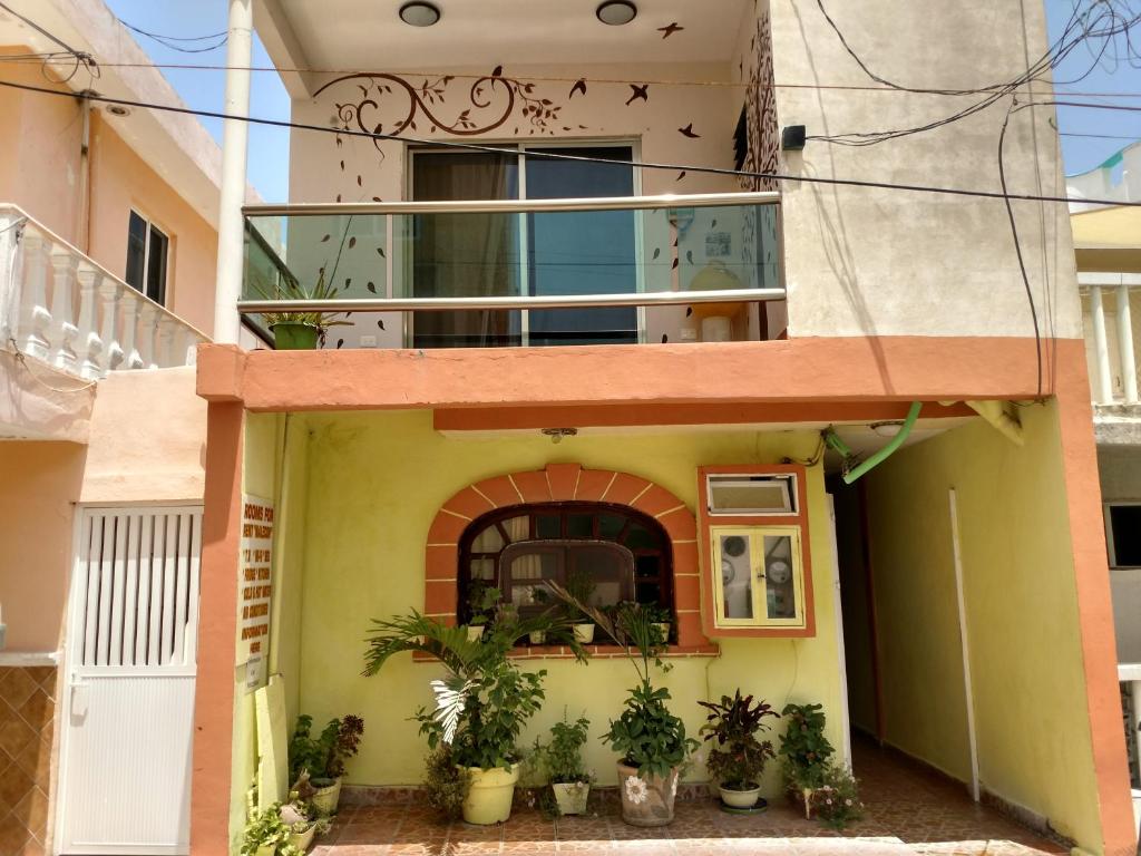 a house with a balcony and plants in front of it at El Malecon, Central Mini Apartments in Isla Mujeres