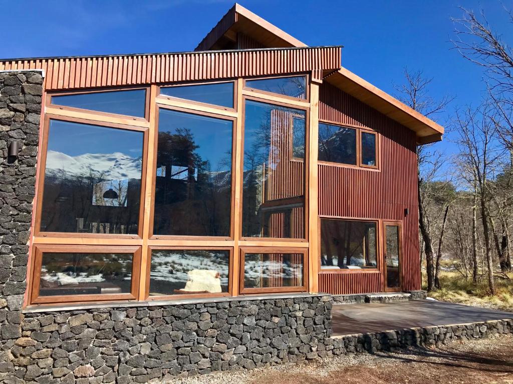 una casa con grandes ventanas de cristal en un lateral en Chalet Ciprés, en Las Trancas