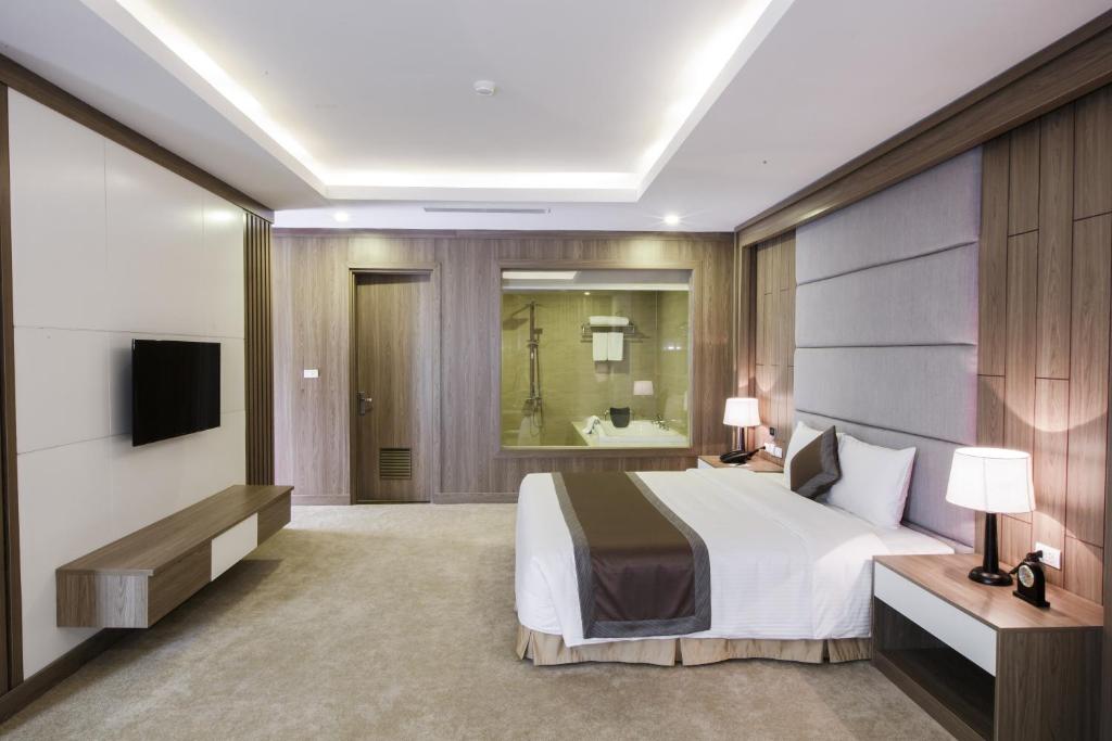 Phủ LýにあるMuong Thanh Luxury Ha Namのベッドとテレビが備わるホテルルームです。