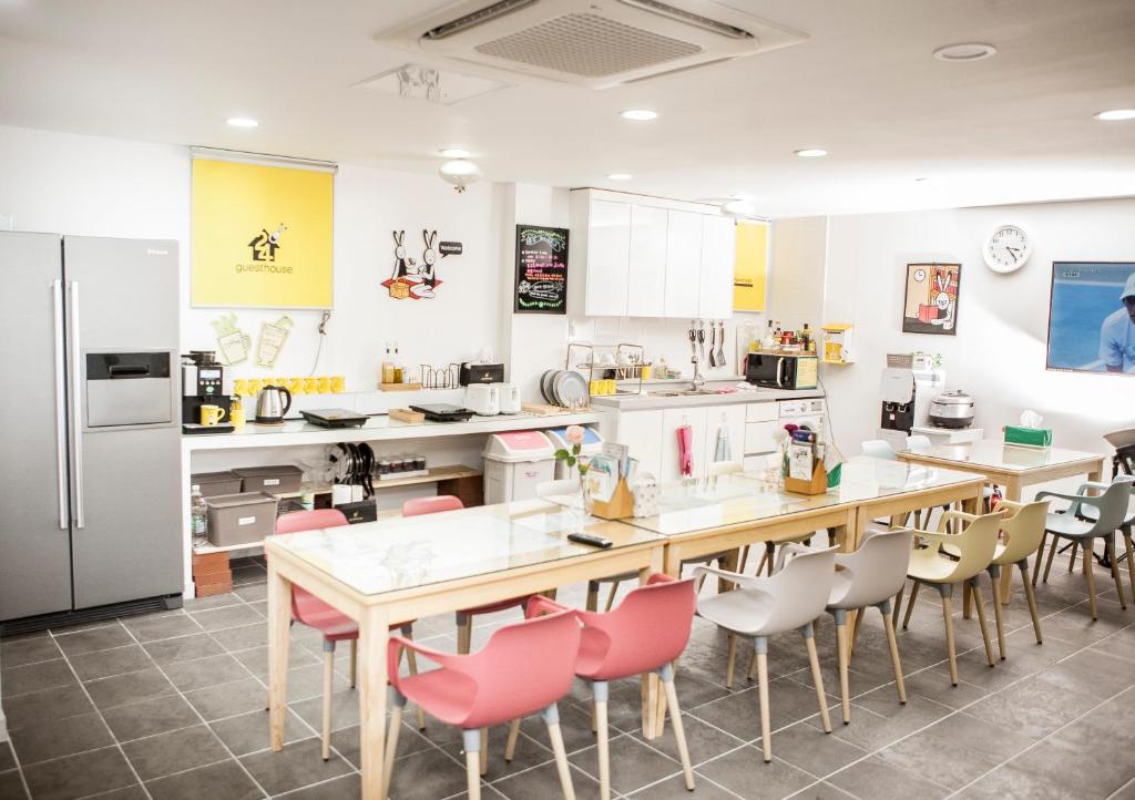 una cocina con una mesa larga y sillas en 24 Guesthouse Jeonju en Jeonju