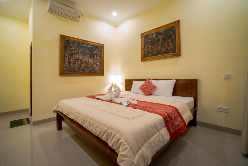 een slaapkamer met een bed met een knuffeldier erop bij Omank Agus Homestay in Ubud