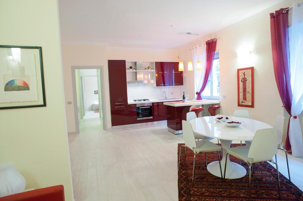 una cucina e una sala da pranzo con tavolo e sedie bianchi di Apartment Home Marconi25 a Verona