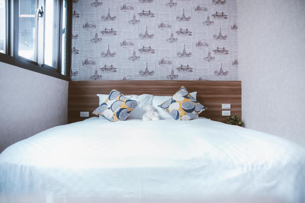a bedroom with a large bed with white sheets and pillows at Meng Yun Ge Hotel in Jiaoxi