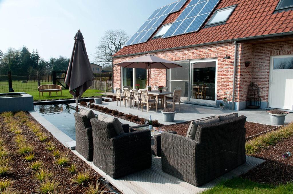 a patio with a table and chairs and an umbrella at B&B Welcome Home in Laakdal