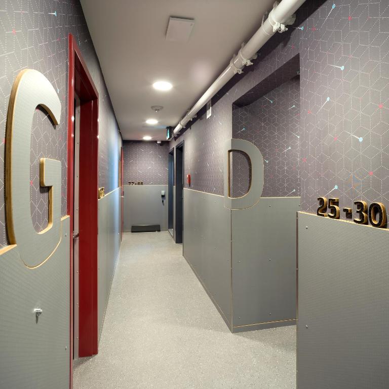 a hallway with the word pay on the wall at Pangea Pod Hotel in Whistler