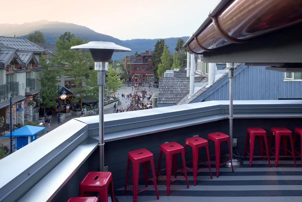 a row of red stools sitting on a balcony at Pangea Pod Hotel in Whistler