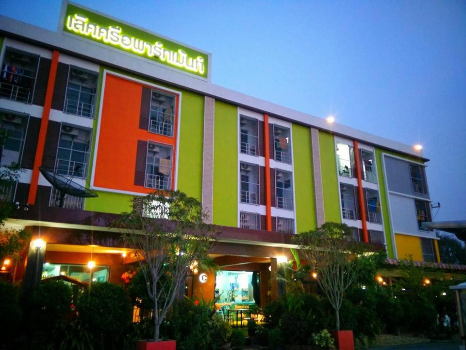 Lert Sri Hotel في U Thong: مبنى بألوان زاهية عليه لافتة