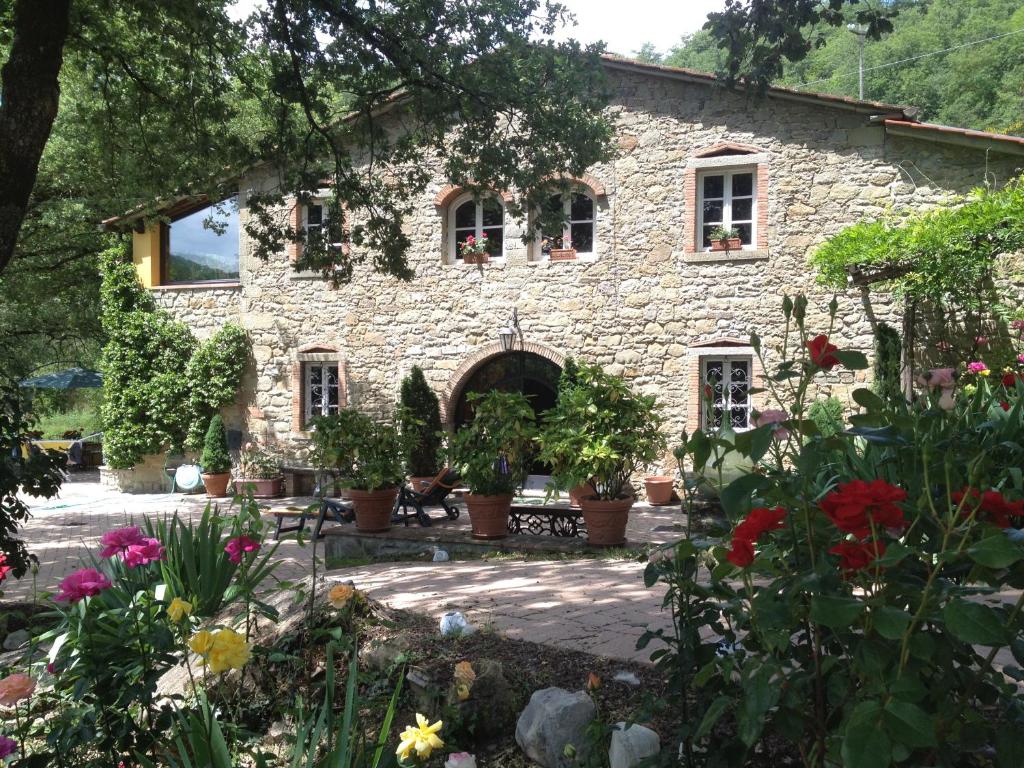 uma casa de pedra com flores em frente em Agriturismo Fattoria Il Ginepro em Talla