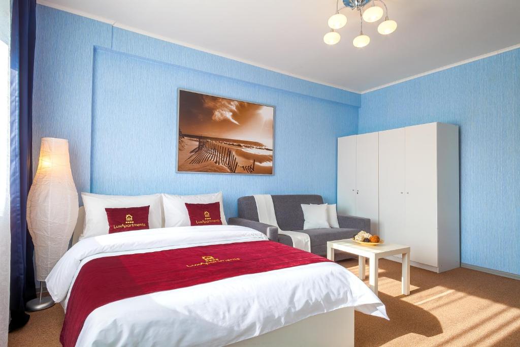 モスクワにあるLux-Apartments метро Тульскаяの青い壁のベッドルーム1室、ベッド1台、椅子1脚が備わります。