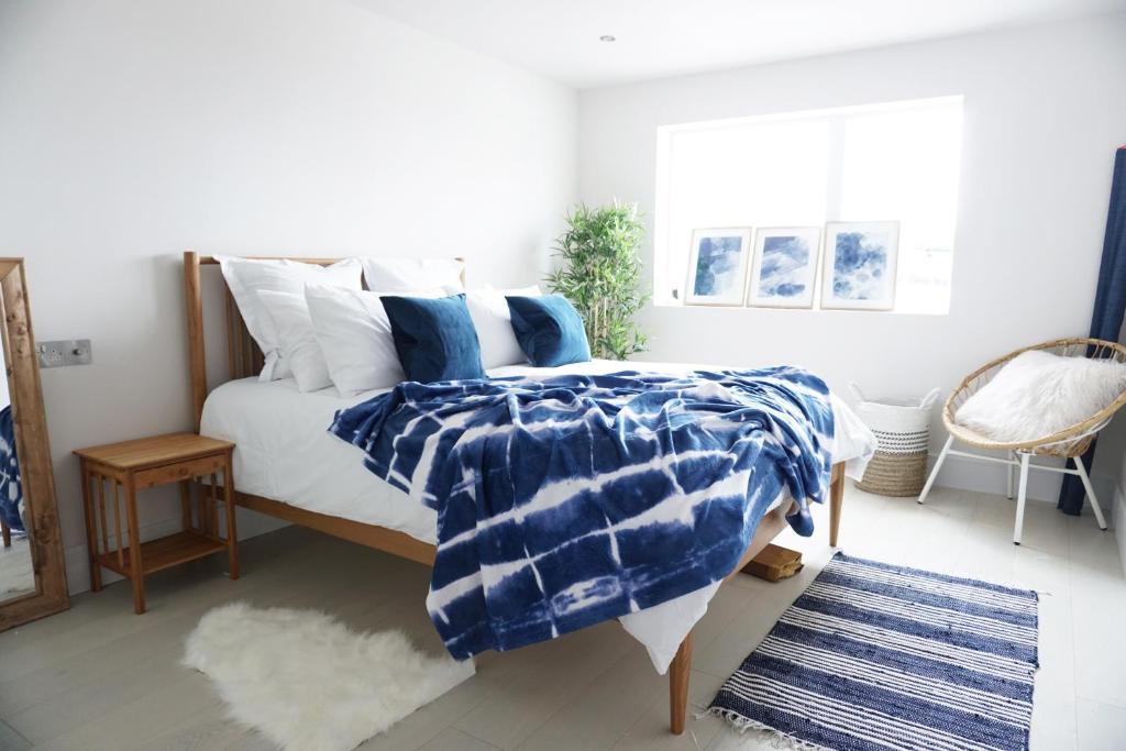 1 dormitorio con 1 cama con almohadas azules y blancas en Saltwater Newquay, en Newquay