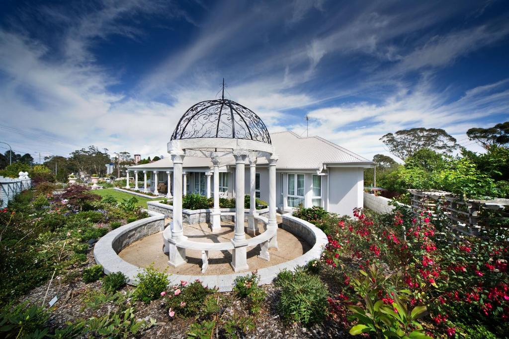 a white house with a gazebo in a garden at Katoomba Manor in Katoomba