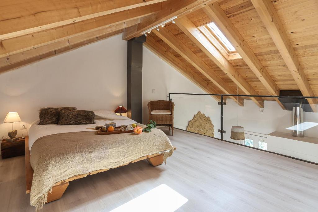 1 dormitorio con 1 cama en una habitación con techos de madera en Cop de Vent, en Dorria