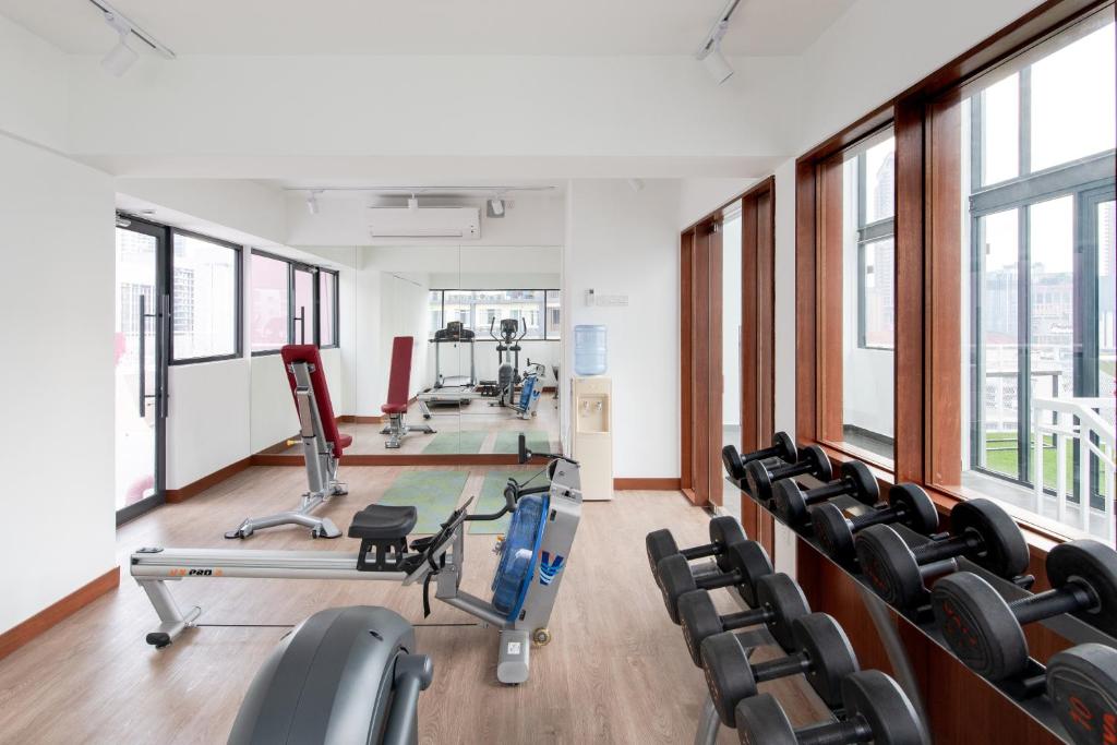 a gym with cardio equipment and chairs in a building at The Kuala Lumpur Journal Hotel in Kuala Lumpur