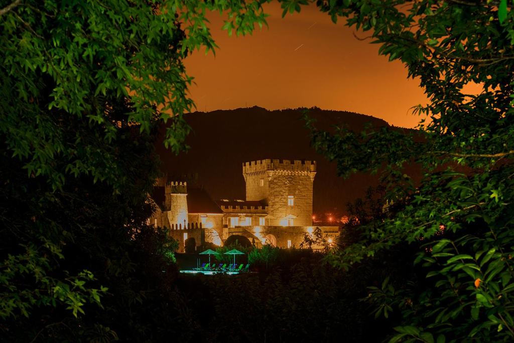 un castillo se ilumina por la noche en Torre de Tebra en Tomiño