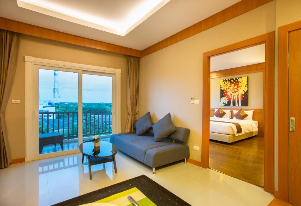 uma sala de estar com um sofá e uma cama em Romantic Khon Kaen Hotel em Khon Kaen