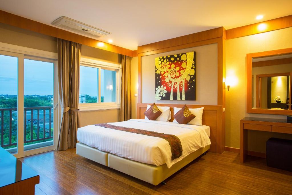 Postel nebo postele na pokoji v ubytování Romantic Khon Kaen Hotel