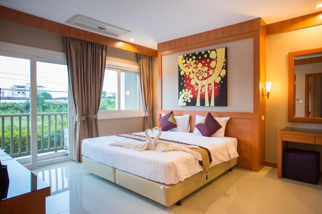 Postel nebo postele na pokoji v ubytování Romantic Khon Kaen Hotel