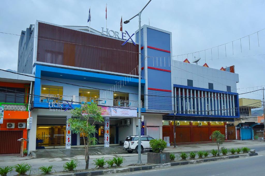 a building with a car parked in front of it at Horison Express Sentani in Jayapura