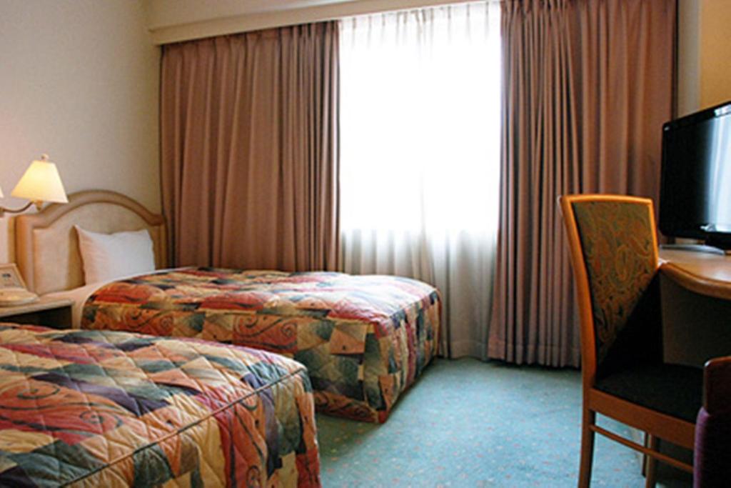 Postel nebo postele na pokoji v ubytování Takarazuka Washington Hotel