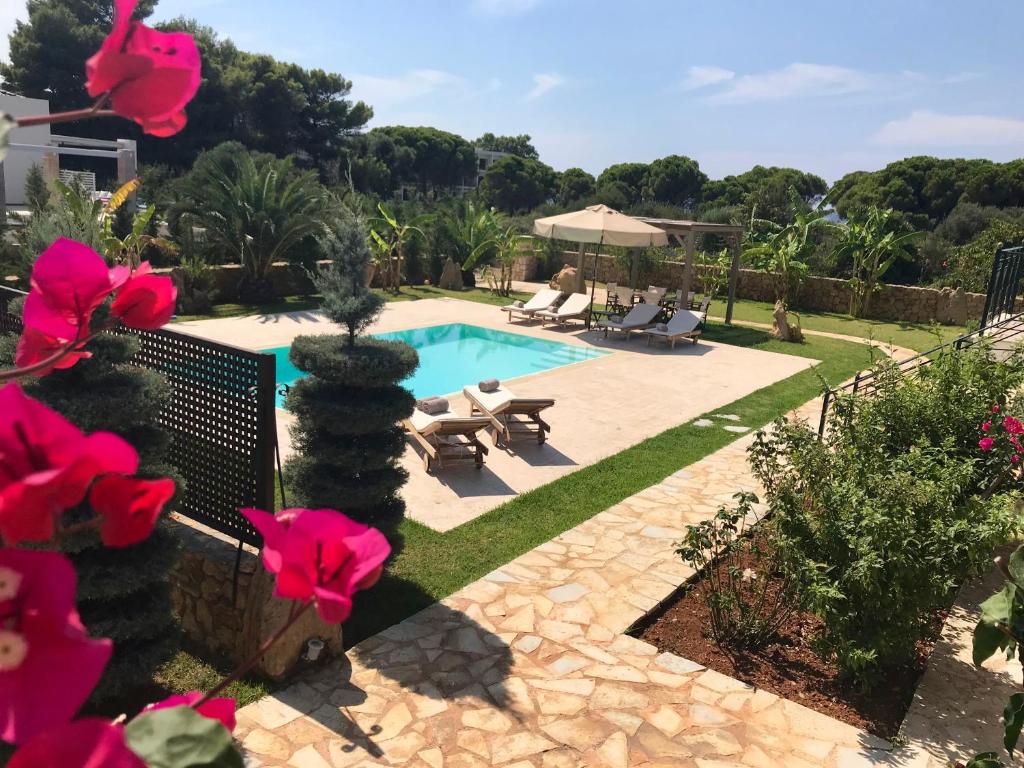 a swimming pool in a yard with pink flowers at Dolce Vita Villas in Svoronata