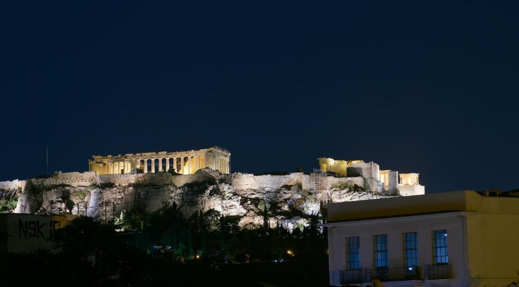um edifício no topo de uma montanha à noite em Thission Luxury Homes & SPA by K&K em Atenas