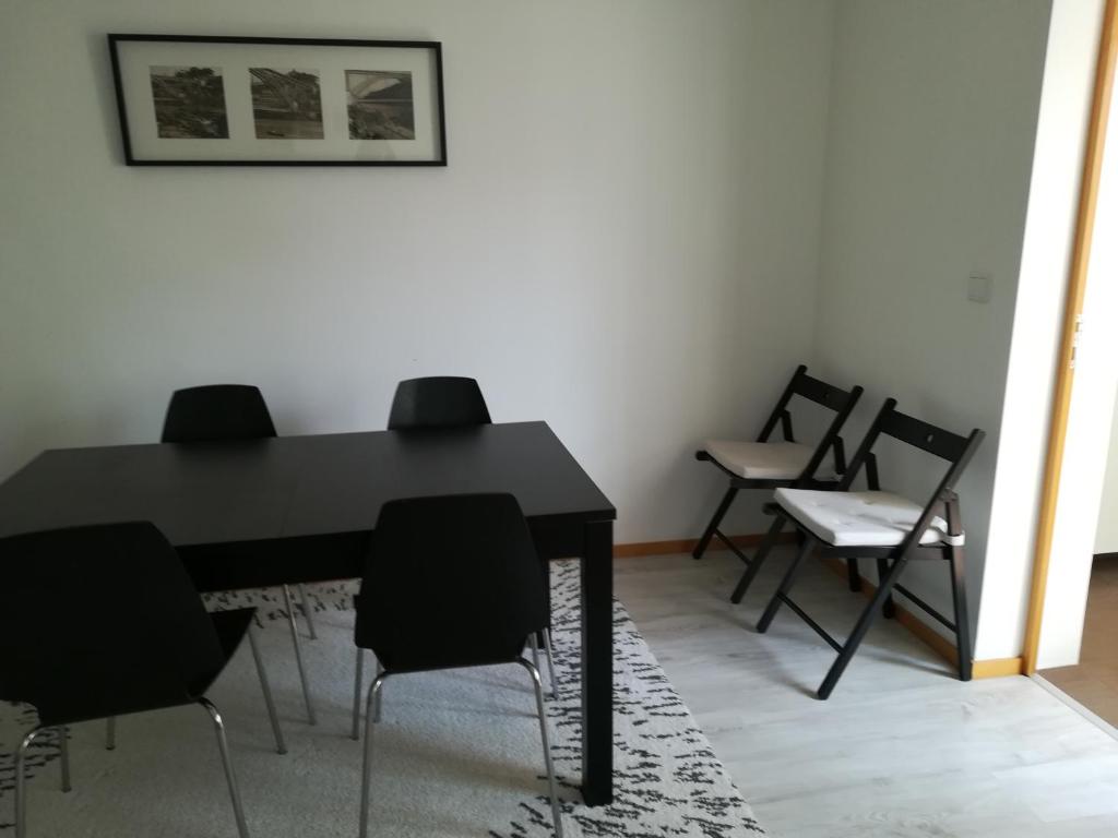 ポルトにあるKris Apartments Portoのダイニングルーム(黒いテーブルと椅子付)