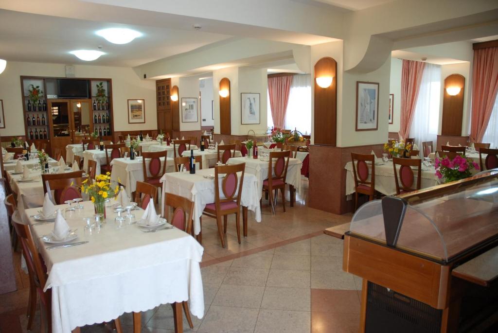 a dining room with white tables and chairs at Il Nocchiero City Hotel in Soverato Marina