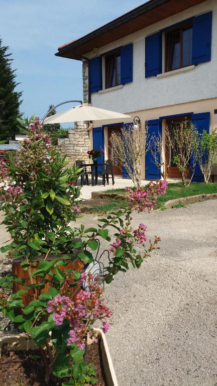 ein blaues Gebäude mit Blumen davor in der Unterkunft Au Doubs Cocon Fleuri in Mamirolle
