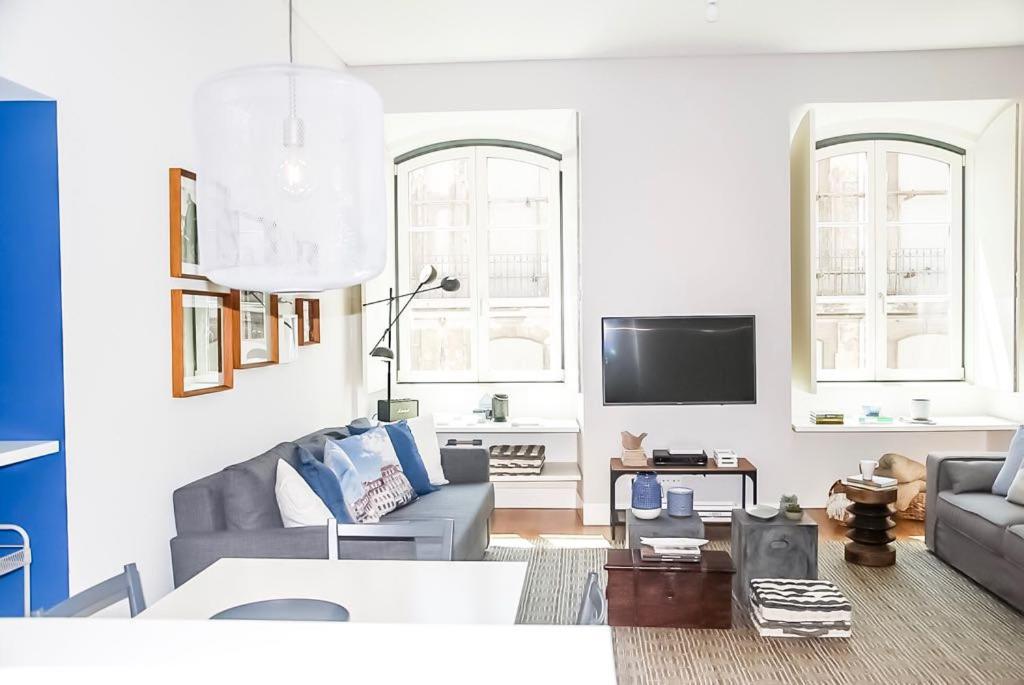 uma sala de estar com um sofá e uma televisão em Luxury and Beautiful Apartment in Chiado em Lisboa