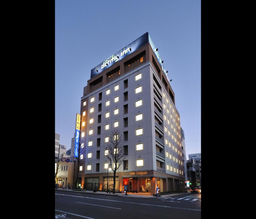 Un bâtiment avec un panneau en haut dans l'établissement Dormy Inn Matsumoto, à Matsumoto