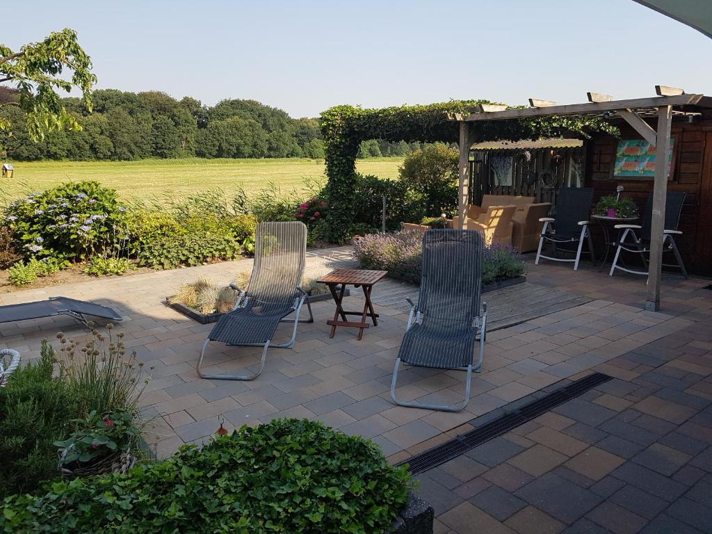 een patio met 2 stoelen en een tafel en stoelen bij Anja's House in Breda